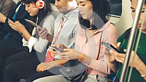 Young people using mobile phone in public underground train