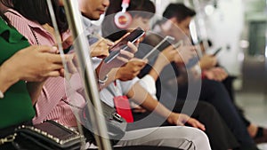 Young people using mobile phone in public underground train