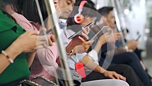 Young people using mobile phone in public underground train