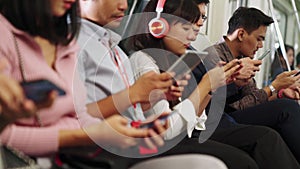 Young people using mobile phone in public underground train