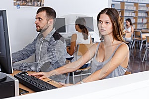 Young people using pc in library