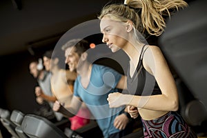 Young people using threadmill in modern gym