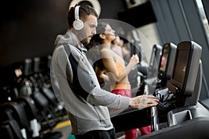 Young people using threadmill in modern gym