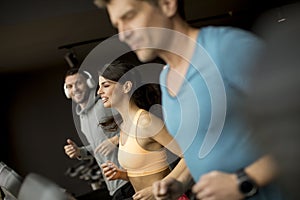 Young people using threadmill in modern gym