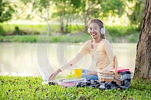 Young people work from home with laptop and listing music in morning relax at nature garden home