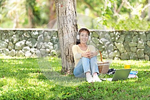 Young people work from home with laptop and listing music in morning relax at nature garden home.