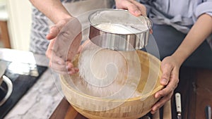 Young people work together to mix the ingredients in a wooden bowl