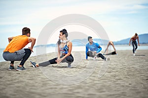 Young people worming up for a training on the beach