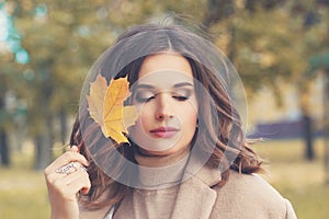 Young perfect female face. Beautiful woman in autumnal park