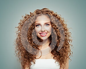 Young perfect redhead woman with long healthy curly hair and cute smile. Beautiful female face photo