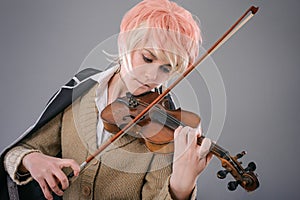 Young performer woman playing the violin.