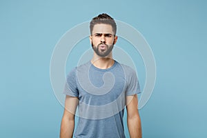 Young perplexed confused irritated man in casual clothes posing isolated on blue wall background, studio portrait