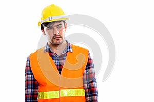 Young Persian man construction worker thinking while looking sad