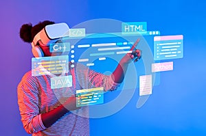 Young Person Engaged in Virtual Reality Programming with Coding Languages Displayed in a Futuristic Digital Environment