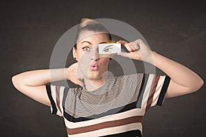 Young person holding paper with angry eye drawing