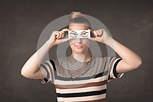 Young person holding paper with angry eye drawing