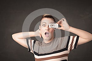 Young person holding paper with angry eye drawing