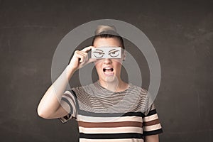 Young person holding paper with angry eye drawing