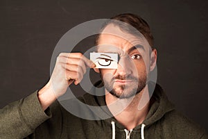 Young person holding paper with angry eye drawing