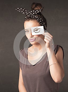 Young person holding paper with angry eye drawing