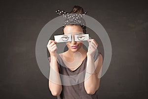 Young person holding paper with angry eye drawing