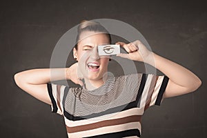 Young person holding paper with angry eye drawing