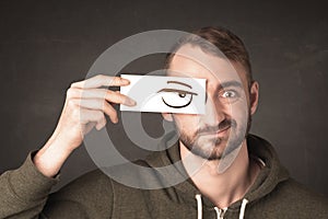 Young person holding paper with angry eye drawing