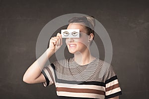 Young person holding paper with angry eye drawing