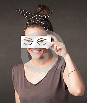 Young person holding paper with angry eye drawing