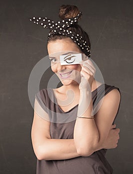 Young person holding paper with angry eye drawing