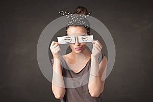 Young person holding paper with angry eye drawing