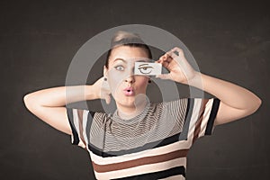 Young person holding paper with angry eye drawing