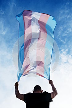 Young person with a transgender pride flag