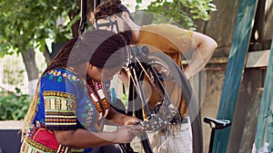 Young persons repairing bicycle outside