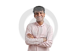 Young peruvian man smile wearing a pink shirt stand with arms crossed, isolated.