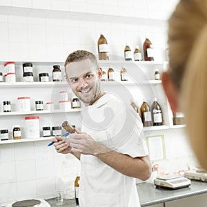 Young pharmacist preparing medicine