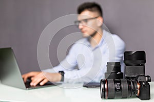 Young professional photographer busy retouching images on his laptop computer from his home