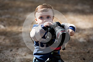 Young photographer child taking photos with camera on a tripod