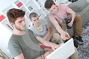 Young photographer choissing with model pictures from laptop