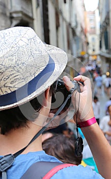 Young photographer with hat takes some picutres of Venice