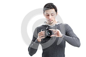 young photographer sets up the camera isolated on white backgrou