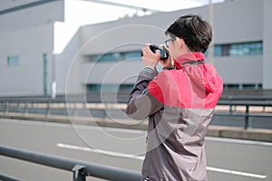 Young photographer shooting photo in the big city from rear view