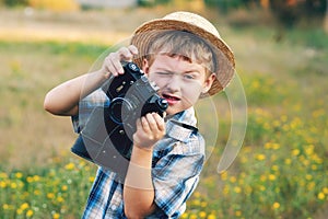 Young photographer in a straw hat with old camera
