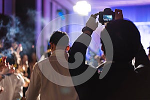 Young photographer taking photo indoor night celebration events, selective focus