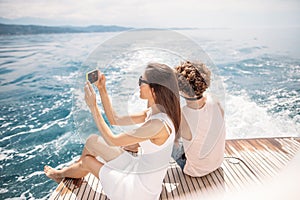 Young photographer taking picture of his girlfriend on seaboat