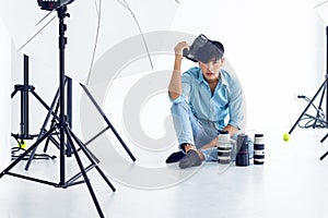 Young photographer is taking pictures in the studio with a digital camera