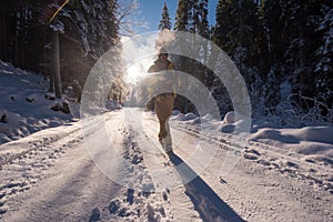 Young photographer walking on snowy country road