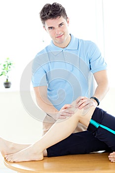 Young physical therapist giving a leg massage photo