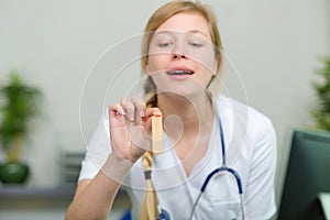young physician holding wooden tongue stick