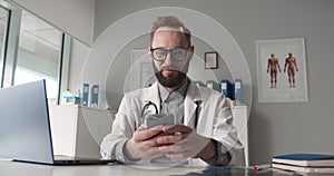 Young physician using mobile app consulting patient online in telemedicine software